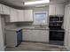 Well-lit kitchen featuring white cabinets, granite counters, and stainless steel appliances for a modern feel at 927 Locke St, Salisbury, NC 28144