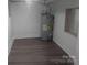 Water heater in a utility room with gray wood-look flooring and a small window at 927 Locke St, Salisbury, NC 28144