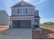 Two-story home featuring a grey exterior, open garage and professionally landscaped front yard at 102 Lightning Dr, Shelby, NC 28152