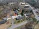 Aerial view shows the home with a pool and large parking area in a residential area at 104 N Hawthorne St, Mount Holly, NC 28120