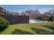 Backyard area with a fenced pool, grass, and shrubs offering privacy and outdoor living at 104 N Hawthorne St, Mount Holly, NC 28120