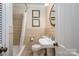 Bathroom showcasing a bathtub with shower, tiled walls, pedestal sink and artwork at 104 N Hawthorne St, Mount Holly, NC 28120
