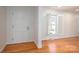 Bright entryway featuring hardwood floors, white trim, an open window, and a classic front door at 104 N Hawthorne St, Mount Holly, NC 28120
