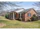 Beautiful brick home featuring a covered porch, well-kept lawn, and mature landscaping at 104 N Hawthorne St, Mount Holly, NC 28120
