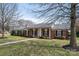 Traditional brick home featuring a covered porch, well-kept lawn, and professional landscaping at 104 N Hawthorne St, Mount Holly, NC 28120