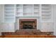 Living room brick fireplace featuring white built-in shelves and cabinets at 104 N Hawthorne St, Mount Holly, NC 28120