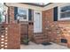 Charming brick front entrance with black shutters and a white front door with storm door at 104 N Hawthorne St, Mount Holly, NC 28120