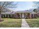 Charming brick home featuring a well-manicured lawn, inviting entryway, and classic architectural details at 104 N Hawthorne St, Mount Holly, NC 28120
