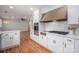 Modern kitchen with stainless hood vent, cooktop, oven, custom cabinets, and hardwood flooring at 104 N Hawthorne St, Mount Holly, NC 28120