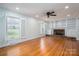 Bright living room features hardwood floors, fireplace with built-ins, and shuttered windows at 104 N Hawthorne St, Mount Holly, NC 28120