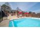 Backyard pool with lounge chairs and umbrellas, surrounded by brick fencing at 104 N Hawthorne St, Mount Holly, NC 28120