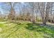 A grassy lawn with shade trees and a small storage shed at 10829 Carmody Ct, Charlotte, NC 28277