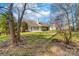 View of the rear of the house and backyard featuring mature trees and landscaping at 10829 Carmody Ct, Charlotte, NC 28277