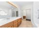 Bathroom featuring dual sinks, a large mirror, walk-in shower with grab bars, and separate toilet area at 10829 Carmody Ct, Charlotte, NC 28277
