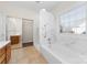 Bathroom with marble details, large tub and window, as well as a door to a walk in closet at 10829 Carmody Ct, Charlotte, NC 28277