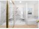 Large accessible shower with marble tile, a bench, and a large tub in this well-lit bathroom at 10829 Carmody Ct, Charlotte, NC 28277
