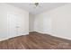 Large bedroom featuring hardwood floors, a ceiling fan, and two closets for storage at 10829 Carmody Ct, Charlotte, NC 28277