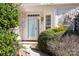 Close-up of the front door with sidelight windows, surrounded by lush greenery at 10829 Carmody Ct, Charlotte, NC 28277