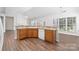 Open kitchen with wood cabinets, tile countertops, stainless steel appliances, and large windows offering natural light at 10829 Carmody Ct, Charlotte, NC 28277