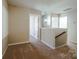 Upstairs hallway provides access to the bedrooms, with carpeted floors, neutral walls, and a modern chandelier at 10943 Trout Creek Pl, Davidson, NC 28036