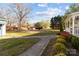 Spacious backyard featuring green grass, mature trees, and pathway leading to home at 1135 Old Charlotte Rd, Concord, NC 28027