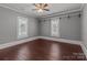 Comfortable bedroom showcasing hardwood floors and natural light from the two windows at 1135 Old Charlotte Rd, Concord, NC 28027