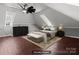 Cozy bedroom featuring sloped ceilings, hardwood floors, and stylish furnishings at 1135 Old Charlotte Rd, Concord, NC 28027