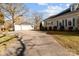 View of long driveway leading to home with garage and mature trees at 1135 Old Charlotte Rd, Concord, NC 28027