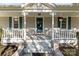 Close-up of the front porch with a teal door, white columns, and decorative hanging flower baskets at 1135 Old Charlotte Rd, Concord, NC 28027