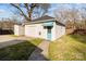 Detached garage with a single car bay, blue door, and small storage shed nearby at 1135 Old Charlotte Rd, Concord, NC 28027