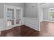 Hallway featuring hardwood floors, decorative wall paneling, and glass paneled doors at 1135 Old Charlotte Rd, Concord, NC 28027