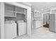 Bright laundry room with white washer and dryer, marble floors, and ample storage cabinets at 1135 Old Charlotte Rd, Concord, NC 28027