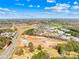 Aerial view of a construction site with a new road among trees under a clear blue sky with puffy clouds at 121 Winners Cir # 2, Mooresville, NC 28117