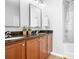 Bathroom with dual sinks with granite counters, wooden cabinets and bath tub with shower at 12417 Mcgrath Dr, Charlotte, NC 28269