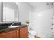 Bathroom featuring a shower-tub combo with wooden cabinets, a marble countertop, and a plant at 12417 Mcgrath Dr, Charlotte, NC 28269