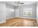 A well-lit living room showcasing wood floors, large windows, and a ceiling fan at 12417 Mcgrath Dr, Charlotte, NC 28269