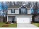 Charming two-story home featuring a two-car garage, covered porch, and neutral siding with blue accent at 125 Lightning Dr, Shelby, NC 28152