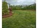 Expansive backyard featuring lush green grass and decorative trees, perfect for outdoor activities at 13217 Oak Farm Ln, Huntersville, NC 28078