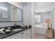 Bright bathroom featuring a vanity with dark countertop and a glimpse into the bedroom at 13217 Oak Farm Ln, Huntersville, NC 28078