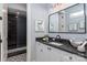 Stylish bathroom with black granite countertop, white cabinetry, and a tiled walk-in shower at 13217 Oak Farm Ln, Huntersville, NC 28078