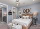 Spacious bedroom with a plush bed, light blue walls, and ensuite access to a bathroom offers a peaceful retreat at 13217 Oak Farm Ln, Huntersville, NC 28078