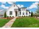 Charming white home with manicured lawn, flower beds, and a inviting brick pathway at 13217 Oak Farm Ln, Huntersville, NC 28078