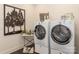 Modern laundry room with front-loading washer and dryer and decorative wall art at 13217 Oak Farm Ln, Huntersville, NC 28078
