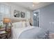 Cozy bedroom with paneled accent wall, soft blue paint, and decorative lamps at 13217 Oak Farm Ln, Huntersville, NC 28078