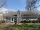 Back of home featuring a brick patio, gray siding and large windows for ample natural light at 1347 Eisenhower Nw Pl, Concord, NC 28027