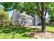 Landscaped backyard features a brick patio, green grass, mature tree, and a fenced perimeter at 1347 Eisenhower Nw Pl, Concord, NC 28027