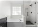 Bright bathroom featuring a tub, a walk-in shower, and modern fixtures at 1347 Eisenhower Nw Pl, Concord, NC 28027