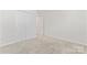 Bedroom with neutral carpet, white walls, and a double door closet in a well-lit home at 1347 Eisenhower Nw Pl, Concord, NC 28027