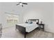 Comfortable bedroom with a ceiling fan, a bed with side tables, and a view to the outside at 1347 Eisenhower Nw Pl, Concord, NC 28027