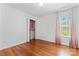 Sunlit bedroom features hardwood floors, a closet with custom organizers and light-filtering curtains at 1347 Eisenhower Nw Pl, Concord, NC 28027